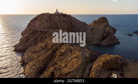 Luftaufnahme des Leuchtturms auf der Insel Pietra mit einer gelben Fähre im Hafen von Île Rousse im Hintergrund, Oberes Korsika, Frankreich - Bild Stockfoto