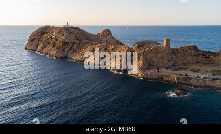 Luftaufnahme des Leuchtturms auf der Insel Pietra mit einer gelben Fähre im Hafen von Île Rousse im Hintergrund, Oberes Korsika, Frankreich - Bild Stockfoto