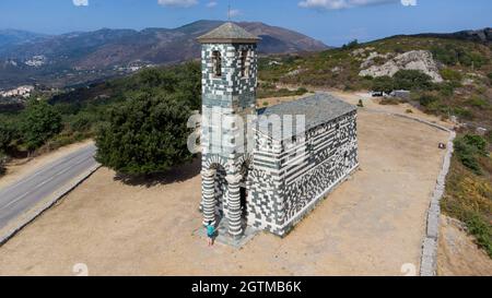 Luftaufnahme der Kirche des Heiligen Michael von Murato in Oberkorsika, Frankreich - Polychromatische Steinkirche mit einem grün-weißen Glockenturm in der Moun Stockfoto