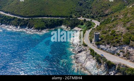 Luftaufnahme der Ruinen des runden genuesischen Turms von l'Osse auf dem Cap Corse, Korsika, Frankreich - Überreste eines mittelalterlichen Aussichtspunktes in der Kurve einer Straße Stockfoto