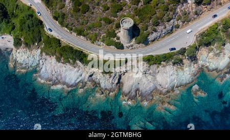 Luftaufnahme der Ruinen des runden genuesischen Turms von l'Osse auf dem Cap Corse, Korsika, Frankreich - Überreste eines mittelalterlichen Aussichtspunktes in der Kurve einer Straße Stockfoto