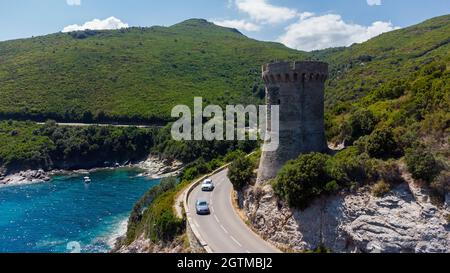 Luftaufnahme der Ruinen des runden genuesischen Turms von l'Osse auf dem Cap Corse, Korsika, Frankreich - Überreste eines mittelalterlichen Aussichtspunktes in der Kurve einer Straße Stockfoto