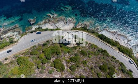 Luftaufnahme der Ruinen des runden genuesischen Turms von l'Osse auf dem Cap Corse, Korsika, Frankreich - Überreste eines mittelalterlichen Aussichtspunktes in der Kurve einer Straße Stockfoto