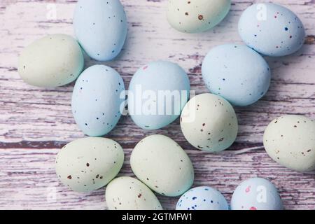 Gelbe und blaue Dragee-Eier auf Weißem Holzhintergrund, Makrofarbenfoto Stockfoto