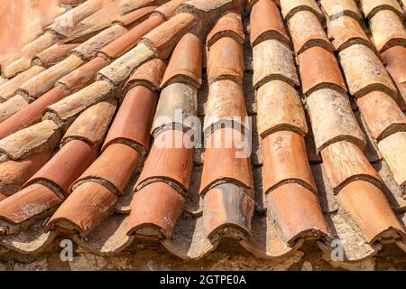 Dachziegel Hintergrund und Textur. Rotes gewelltes Dachziegelelement, traditionelles Hausdach, Überlagerungsmuster Stockfoto