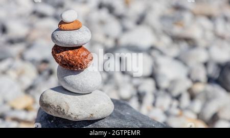 Zen-Balancesteine, glatter Felsturm auf Kiesstrand im Hintergrund, sonniger Tag. Harmony and Peace Konzept, Kopierraum, Vorlage Stockfoto