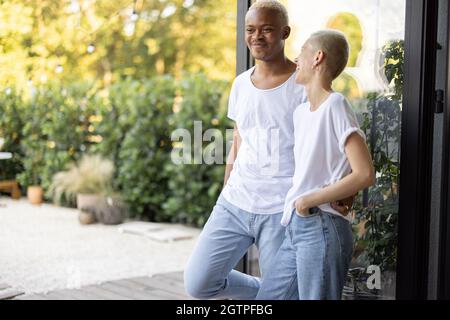 Multirassisches Paar steht auf der heimischen Terrasse zusammen Stockfoto