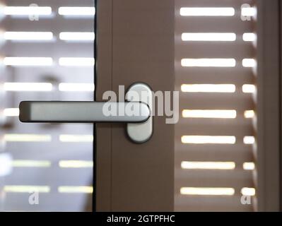 Aluminiumfenster. Türrahmen und Jalousien aus Stahl oder Kunststoff öffnen, Nahaufnahme des Griffs. Stockfoto