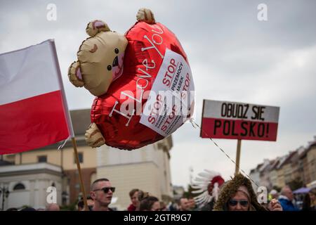 Warschau, Polen. Oktober 2021. Während der Demonstration halten Demonstranten ein Plakat und einen Ballon mit Parolen.Hunderte von Menschen nahmen an dem jährlichen Marsch der Freiheit und Souveränität unter dem Motto "Stop Sanitary Segregation" Teil, der von der rechtsextremen nationalistischen Partei der Konföderation (Konfederacja) organisiert wurde. Die Teilnehmer wollten sich gegen die hygienische Segregation und den Zwang zu COVID-19-Impfungen aussprechen. Kredit: SOPA Images Limited/Alamy Live Nachrichten Stockfoto