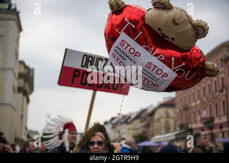 Warschau, Polen. Oktober 2021. Während der Demonstration halten Demonstranten ein Plakat und einen Ballon mit Parolen.Hunderte von Menschen nahmen an dem jährlichen Marsch der Freiheit und Souveränität unter dem Motto "Stop Sanitary Segregation" Teil, der von der rechtsextremen nationalistischen Partei der Konföderation (Konfederacja) organisiert wurde. Die Teilnehmer wollten sich gegen die hygienische Segregation und den Zwang zu COVID-19-Impfungen aussprechen. Kredit: SOPA Images Limited/Alamy Live Nachrichten Stockfoto