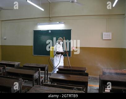 Mumbai, Indien. Oktober 2021. Ein Mann, der in einem Schutzanzug gekleidet ist, sprüht Desinfektionsmittel in einem Klassenzimmer der Sion Municipal High School als vorbeugende Maßnahme gegen die Ausbreitung von covid-19. (Foto von Ashish Vaishnav/SOPA Images/Sipa USA) Quelle: SIPA USA/Alamy Live News Stockfoto