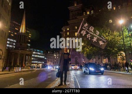 Finn Lau, Gründer der Hong Kong Liberty, wurde dabei gesehen, wie er die Flagge mit den Worten „Free Hong Kong“ schwenkte. Revolution Now“ während der Demonstration. Am 1. Oktober kamen verschiedene anti-chinesische Diasporas in London zusammen, um sich solidarisch gegen die Kommunistische Partei Chinas zu zeigen. Gemeinsam gehalten von Hong Kong Liberty, dem Welt-Uiguren-Kongress, Free Tibet und mehr, wurden im Piccadilly Circus Reden gehalten, um die Menschenrechtsverletzungen durch die KPCh zu verurteilen. Die Demonstranten marschierten später zur chinesischen Botschaft in London, wo die chinesische Nationalflagge verbrannt wurde. Stockfoto