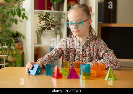 Mädchen mit Down-Syndrom studiert geometrische Formen Stockfoto