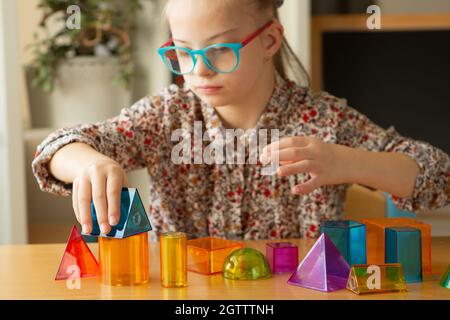 Mädchen mit Down-Syndrom studiert geometrische Formen Stockfoto