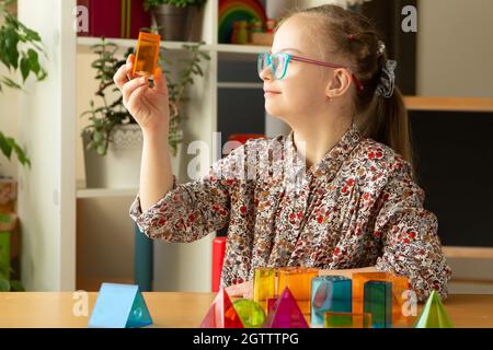 Mädchen mit Down-Syndrom studiert geometrische Formen Stockfoto