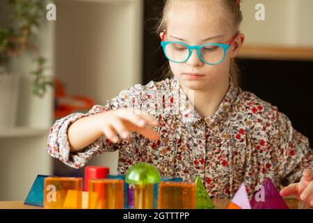 Mädchen mit Down-Syndrom studiert geometrische Formen Stockfoto