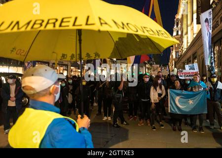 Ein Protestler sah während der Demonstration einen Regenschirm mit der Aufschrift „Umbrella Revolution“ in der Hand halten. Am 1. Oktober kamen verschiedene anti-chinesische Diasporas in London zusammen, um sich solidarisch gegen die Kommunistische Partei Chinas zu zeigen. Gemeinsam gehalten von Hong Kong Liberty, dem Welt-Uiguren-Kongress, Free Tibet und mehr, wurden im Piccadilly Circus Reden gehalten, um die Menschenrechtsverletzungen durch die KPCh zu verurteilen. Die Demonstranten marschierten später zur chinesischen Botschaft in London, wo die chinesische Nationalflagge verbrannt wurde. (Foto von Belinda Jiao/SOPA Images/Sipa USA) Stockfoto