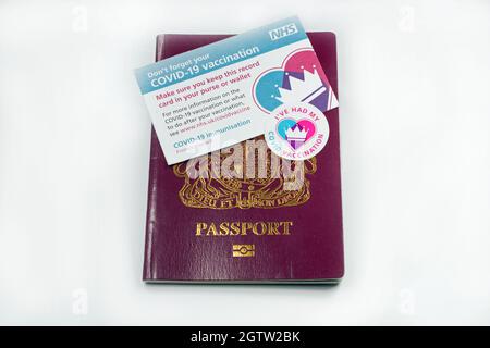 Covid-Impfpass auf einem Pass vor einem Hintergrund. Stockfoto