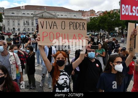 Lissabon, Portugal. Oktober 2021. Ein Aktivist hält ein Plakat, das den brasilianischen Präsidenten Jair Bolsonaro während einer Kundgebung auf dem Rossio-Platz ablehnt. Die in Lissabon verschiedene Organisationen, Parteien, Gewerkschaften und Bewegungen für Demokratie und die Rechte des Volkes zusammenbringt, veranstaltete eine Kundgebung zur Ablehnung der Politik des brasilianischen Präsidenten Jair Bolsonaro und forderte seinen Rücktritt als Staatsoberhaupt. Kredit: SOPA Images Limited/Alamy Live Nachrichten Stockfoto