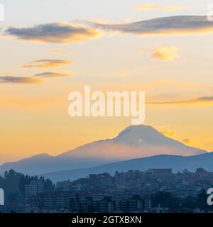 Vulkan Cayambe bei Sonnenaufgang im quadratischen Format mit Skyline von Quito, Ecuador. Stockfoto