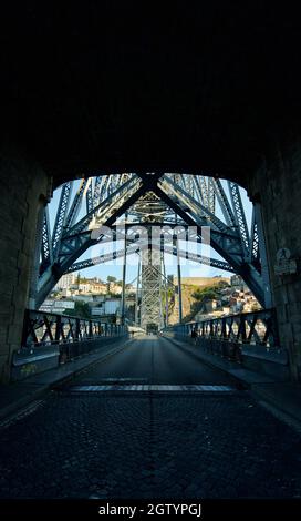 Blick unter/unter der Brücke Luís I, Porto, Portugal . Die Dom Luís i Brücke, von unten gesehen entlang der Straße/Pfad. Doppelstockbrücke in B&W. Stockfoto