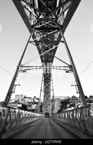 Blick unter/unter der Brücke Luís I, Porto, Portugal . Die Dom Luís i Brücke, von unten gesehen entlang der Straße/Pfad. Doppelstockbrücke in B&W. Stockfoto