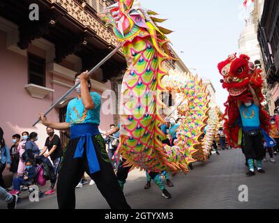 Löwe- und Drachentanz der Künstlerischen Löwengruppe der chinesischen Wohltätigkeitsgesellschaft, die durch die Straßen von Lima, der Hauptstadt Perus, im Rahmen der Feierlichkeiten zur feierlichen Proklamation der Gründung der Volksrepublik China am 1. Oktober 1949 auftrat. Stockfoto