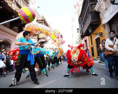 Löwe- und Drachentanz der Künstlerischen Löwengruppe der chinesischen Wohltätigkeitsgesellschaft, die durch die Straßen von Lima, der Hauptstadt Perus, im Rahmen der Feierlichkeiten zur feierlichen Proklamation der Gründung der Volksrepublik China am 1. Oktober 1949 auftrat. Stockfoto