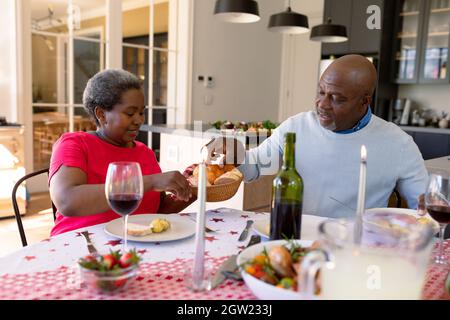 Glückliches afroamerikanisches Seniorenpaar, das zu Hause weihnachtsessen hat Stockfoto