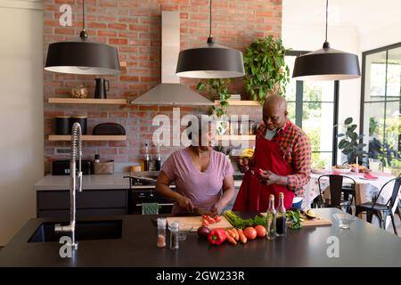 Glückliches afroamerikanisches Seniorenpaar kocht zusammen in der Küche Stockfoto