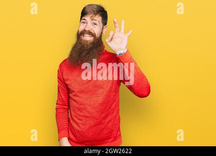 Rotschopf Mann mit langen Bart tragen lässige Kleidung lächelnd positiv tun ok Zeichen mit Hand und Fingern. Erfolgreicher Ausdruck. Stockfoto