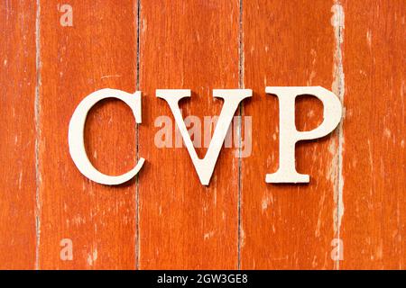 Buchstabenbuchstabe in Wort CVP (Abkürzung für (Cost Volume Profit oder Central Venous Pressure) auf altem, rotem Hintergrund der Holzplatte Stockfoto