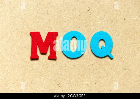 Farbe Tuch Alphabet Buchstaben in Wort MOQ (Abkürzung für Minimum Order Quantity) auf Holz Hintergrund Stockfoto