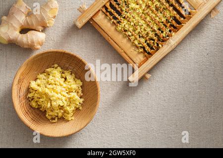 Frisches Ingwergranulat in Waschbrett und Holzplatte, frischer Ingwer auf der Wäsche Stockfoto