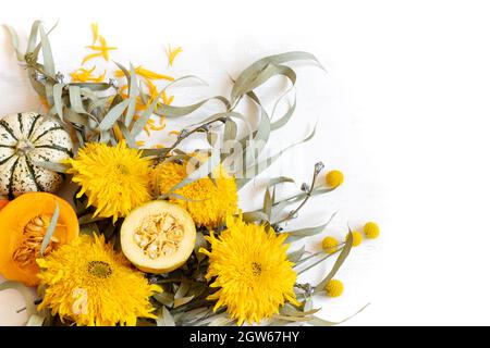 Festliches Herbstdekor aus Kürbissen und Blumen auf weißem Hintergrund, Kopierfläche. Konzept des Erntedankfestes oder Halloween. Stockfoto