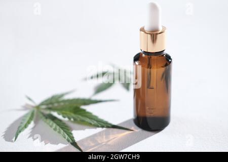 Medizinisches Marihuana Cannabis CBD-Öl in Bernsteinglasflasche mit Tropf. THC-Tinktur und Hanfblätter, Kräuterbehandlung, Alternative Medizin. Für Kalmin Stockfoto