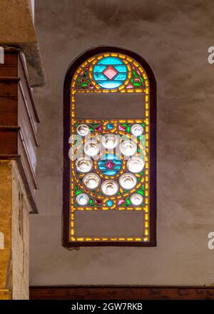 Perforiertes Stuckfenster mit buntem Fleckglas und geometrischen kreisförmigen Mustern, gelegen im öffentlichen historischen Beschtak-Palast aus der Mamluk-Ära, in der Moez Street, Kairo, Ägypten Stockfoto