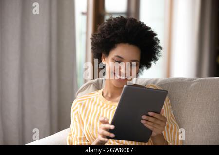 Glückliche afrikanische Ethnizität Frau mit digitalen Tablet. Stockfoto