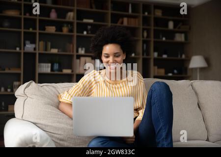 Glückliche junge afroamerikanische Frau mit Computer. Stockfoto