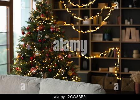 Festlich dekoriertes leeres stilvolles Wohnzimmer mit Weihnachtsbaum. Stockfoto