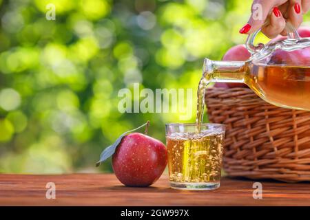 apfelwein oder Saft in Glas aus der Flasche Stockfoto