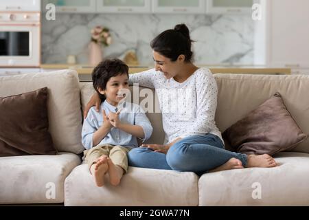 Fürsorgliche junge indische Mutter im Gespräch mit kleinen Sohn Kind. Stockfoto