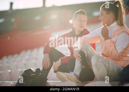 Nach dem Training hingen sportliche Paare draußen zusammen Stockfoto