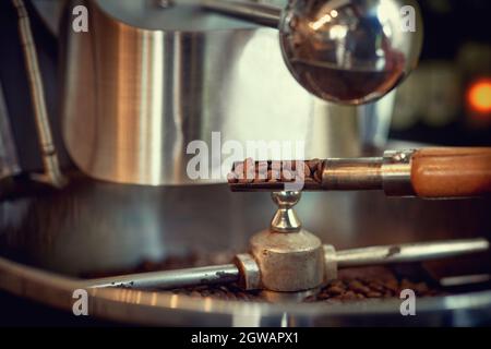 Spatel mit rohen Kaffeebohnen in der Nähe von Sonderausstattung. Stockfoto