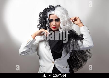 Eine tödliche Schönheit in einem gewagten Modebild mit schwarzen und weißen Haaren. Ein rebellisches stylisches Bild für Halloween. Stockfoto