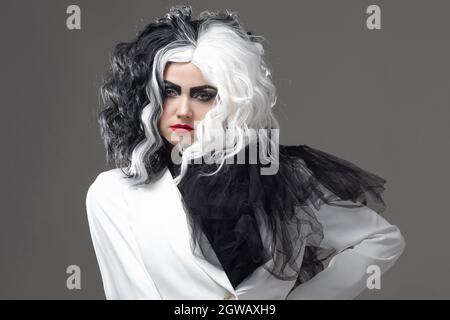 Eine tödliche Schönheit in einem gewagten Modebild mit schwarzen und weißen Haaren. Ein rebellisches stylisches Bild für Halloween. Stockfoto