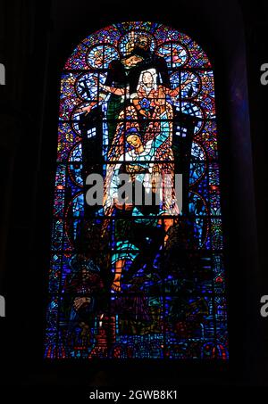 Verzierte viktorianische Kirchenfenster mit Kirchenmalereien, die religiöse Figuren in lebhaften Farben darstellen Stockfoto
