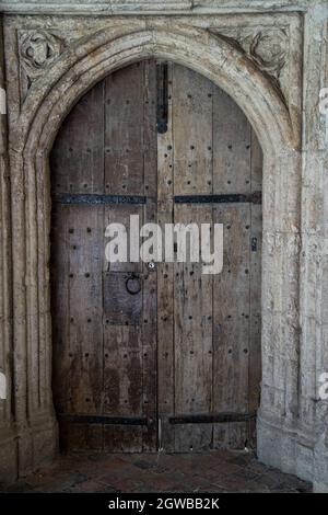 Historische mittelalterliche Holztür mit Steinbogen und geschnitzten Details Stockfoto