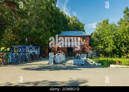 Am Eingang des kleinen Gebäudes befinden sich Grabsteine. Die Inschrift auf dem Gebäude: Friedhofsverwaltung. Das Foto wurde in Chelyabin aufgenommen Stockfoto