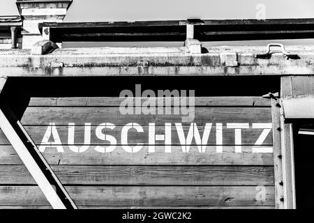 Auschwitz in weißen Großbuchstaben geschrieben auf einem Holzwagen eines alten ursprünglichen Güterzugs auf der Entladeplattform von Birkenau-Auschwitz Stockfoto